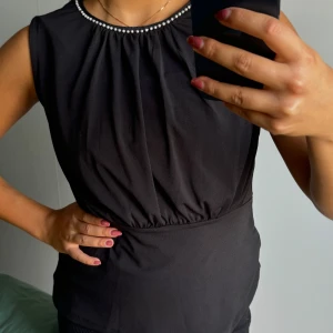 Blus - Blus från Stockholm LM med pärlor vid halsen och resor i midjan.  använd endast en gång 