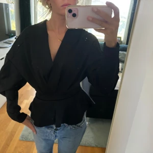 Blus med indragen midja och ballongärmar - Elegant blus med figurnära och indragen midja. Blus med balkongärmar 