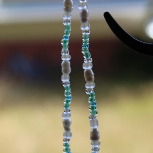 Pärlhalsband i turkos och vitt - Säljer ett superfint pärlhalsband med turkosa och vita pärlor. Perfekt för att ge en bohemisk touch till din outfit. Halsbandet har en enkel och stilren design som passar både till vardags och fest.