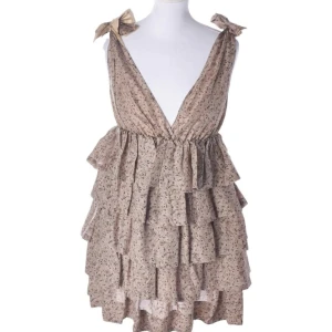 Klänning - Så fin klänning från by malene Birger. Den knyts och justeras i axlarna och är i en brunbeige färg