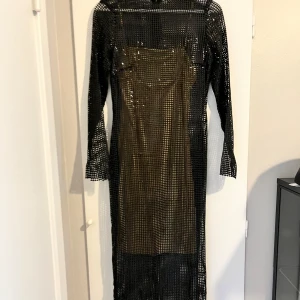 Svart glittrig klänning från Lexi - Säljer en supercool svart glittrig klänning från Lexi. Den har en lång och elegant design med långa ärmar och en genomskinlig look som verkligen sticker ut. Perfekt för en fest eller en utekväll när du vill glänsa! ✨inköpspris 1300