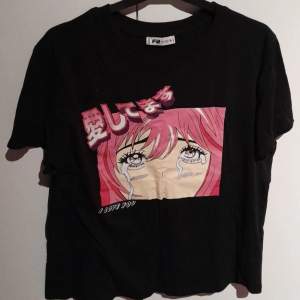 En svart t-shirt med rosa anime-tryck.