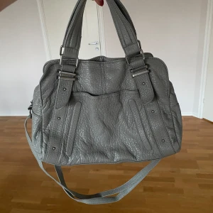Grå väska  - Bra skick inga defekter. Perfekt till skolan rymmer nästan A4. 😊