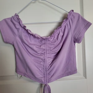 Off shoulder topp - En lila offshoulder topp med snörning och knyte! Använd fåtal gånger och i fintskick