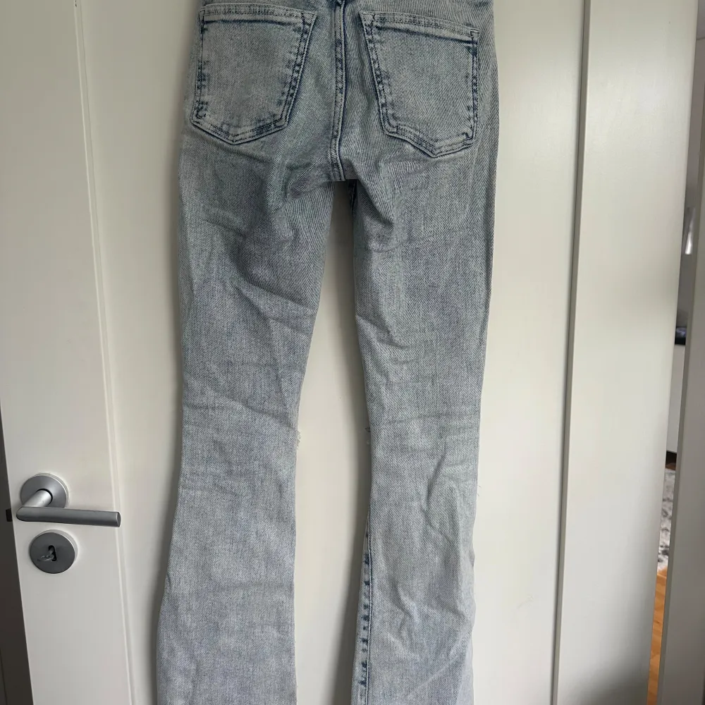 Ljusblåa Bootcut jeans i storlek xs med hål på knäna från bikbok. I bra skick.. Jeans & Byxor.