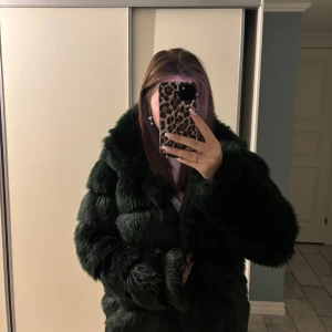 Mörkgrön pälsjacka - Skitsnygg mörkgrön pälsjacka som är perfekt för vintern. Den är jätte varm och har extra långa ärmar. Stl 36 men passar även 38. Nyskick.