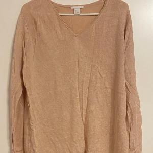 Beige tröja från H&M - Säljer en stilren beige tröja från H&M i storlek S. Den har en v-ringad hals och långa ärmar, perfekt för både vardag och lite finare tillfällen. Materialet känns mjukt och bekvämt mot huden. Passar perfekt till höst- och vårgarderoben!