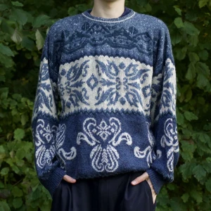 Mönstrad stickad tröja i blått och vitt - Säljer en superfin stickad tröja med ett unikt mönster i blått och vitt. Den har långa ärmar och en bekväm passform, perfekt för kyliga dagar. Tröjan är både stilren och mysig, idealisk för höst och vinter. Passar perfekt till jeans eller svarta byxor!