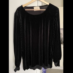 Ribbad sammetströja  - Tröjan har långa ärmar och är ribbad. Perfekt för höst och vinter, och kan lätt kläs upp för festliga tillfällen. Ärmarna slutar i tightare material som ger lite ballongeffekt. Skriv gärna vid frågor! 🩶  Fint skick och knappt använd. (Katt i hemmet)