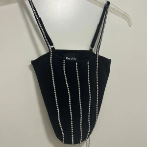 Linne med bling - Ett linne med bling som är köpt i Spanien. Linnet är kort oschysst sitter väldigt snyggt på kroppen. ”Blinget” har ramlat av lite längst ned men är inget man inte kan få att se bra ut ändå!