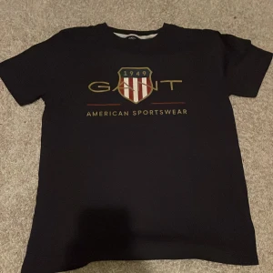 Gant T-shirt  - T-shirt i okej skick. Små hål långt ner på framsidan (se bilder). Storlek 170.
