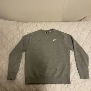 Säljer en stilren grå sweatshirt från Nike i storlek S. Den är i nyskick och är riktigt skön🩶. SKRIV FÖR BÄTTRE BILDER!