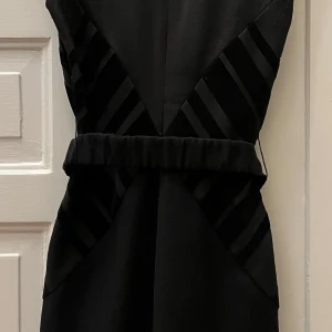 Roberto Cavalli klänning i svart och beige - Roberto Cavalli klänning med hög polokrage i svart och beige, med ett vackert skärp. Jag kan träffas i Stockholm city eller skick den till dig. Med vänlig hälsning Carina Andersson 