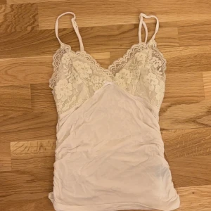 Vit linne med detaljer - knappt använd och banden går att justera. stretchigt material