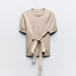 Beige stickad topp från Zara - Säljer en superfin beige stickad topp från Zara. Den har korta ärmar och en snygg knytning i midjan som ger en unik touch. Perfekt för både vår och sommar! 🧶✨ Denna tröjan är väldigt fin och trendig❤️ kan skicka fler bilder❤️