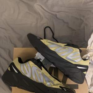 Säljer ett par Adidas YZY 700 MNVN i en cool gul och svart färgkombination. Skorna har en futuristisk design med reflekterande detaljer och en bekväm sula. Perfekta för både vardag och fest! De är i nytt skick och kommer i originalkartong.