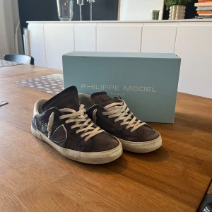 Philippe Model sneakers - Säljer ett par Philippe Model sneakers i grått och vitt. De har en klassisk design med snörning och en bekväm passform. Skorna är i bra skick med lite slitage på sulorna, men de är fortfarande snygga och användbara. Perfekta för vardagsbruk! Säljs för 800 men kan diskuteras.