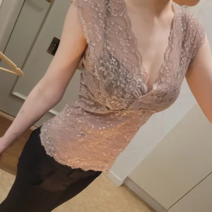 Rosa spetstopp  - Säljer ett snyggt rosa spetslinne med v-ringning och vackra spetsdetaljer. Toppen är ärmlös och har en tight passform som framhäver figuren. Jag är öppen för prisförslag!!🤗🤗 Perfekt för festliga tillfällen eller en utekväll. Passar bra till både kjol och byxor! I storlek L men passar mig som brukar ha XS och S lite stort, skulle säga att den passar S-M!! Säljer ett likadant i en storlek mindre med som passar XS/S🩷🩷🩷 jag är väldigt blek (orkar inte göra bus🤓) men sååååååå snyggt med en bränna!!!
