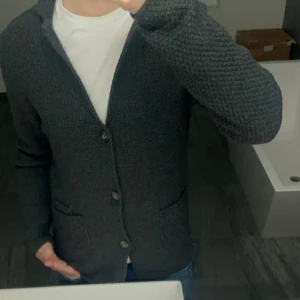 Grå cardigan - Mörk grå cardigan i storlek S men passar M. Mycket bra skick. Jag är 177 cm