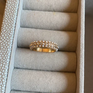 Guldfärgad ring med glittriga stenar - Säljer en elegant guldfärgad ring täckt med stenar från montini. Säljer billigt då jag hällre ser att någon får användning för den istället att den ska bara ligga i mitt smyckesskrin🩷
