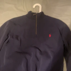 Mörkblå tröja från Polo Ralph Lauren - Säljer en riktigt fet polo ralph lauren half zip som passar perfekt till vår och vinter. Säljer pga den ej har kommit till användning och det vill säga att den är i ett bra skick. Pris kan diskuteras