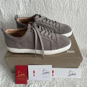Grå sneakers från Christian Louboutin - Säljer ett par snygga grå sneakers från Christian Louboutin i mocka. Skick 10/10, skriv privat för fler frågor.