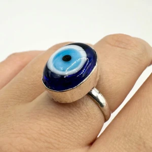 Ring med blått öga silver 925  - Cool ring med ett stort blått öga i centrum. Ringen har en silverfärgad bas och det blå ögat är omgivet av en mörkare blå kant. Perfekt för att ge en mystisk touch till din outfit!