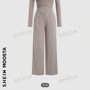 Beige ribbad topp från Shein - Säljer en snygg beige ribbad topp från Shein i storlek XS. Toppen har en unik asymmetrisk design med långa ärmar och en spetsig nederdel. Perfekt för både vardag och fest! 🥳