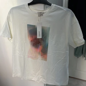 Vit t-shirt med abstrakt tryck från Esprit - Säljer en vit t-shirt från Esprit i bomull. Aldrig använd, lapp finns kvar. 