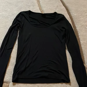 Svart långärmad topp från Gina Tricot - Säljer en svart långärmad topp från Gina Tricot i storlek M. Perfekt för både vardag och fest. Toppen har en kort slit i varje ärm med rund halsringning och är gjord i ett mjukt, stretchigt och bekvämt material. Passar till alla säsonger och kan enkelt matchas med olika outfits.