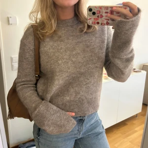 Ull- och mohairtröja från HM - Stickad ull/mohair-tröja i mörk beige från H&M, storlek M. Använd men i jättefint skick, inga defekter. Extra lång ärmar med slits i ändarna. Så himla snygg men kommer inte till tillräcklig användning. Säljs inte längre 🤎