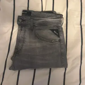 Säljer ett par snygga grå jeans från Replay i storlek 30/32. De har en klassisk femficksdesign och en stilren grå tvätt. Perfekta för både vardag och fest!  Bra skick, enligt bilder! Skicka gärna om det är någon speciell bild som efterfrågas!