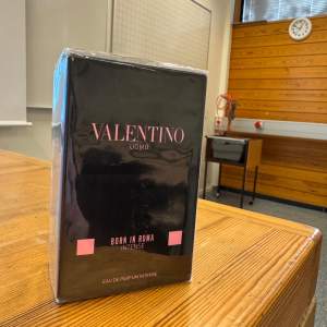 Säljer en lyxig parfym från Valentino, Uomo Born in Roma Intense. Flaskan är svart med en cool, nitat design och rosa text. Perfekt för den som vill ha en intensiv och elegant doft. Helt ny och oöppnad i originalförpackning.jag köpte det på 1500kr och vill sälja den för 1100kr . 