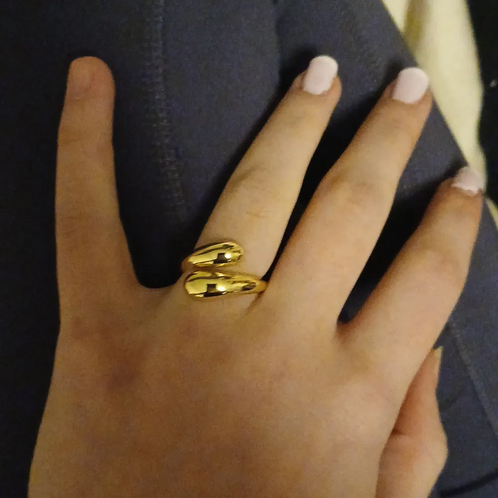 Snygg guldfärgad ring med en modern och stilren design. Ringen har en unik form som slingrar sig runt fingret och ger en elegant touch. Perfekt för både vardag och festliga tillfällen. Passar de flesta storlekar tack vare sin justerbara design.. Accessoarer.