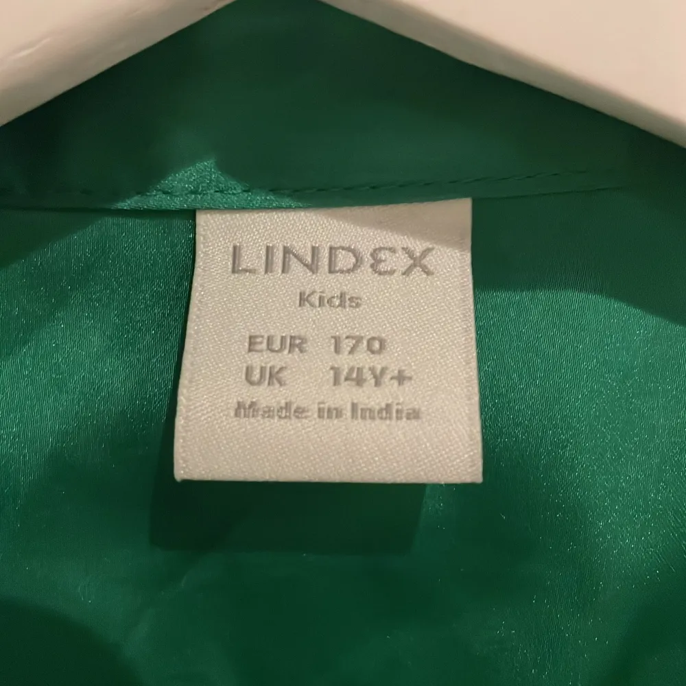 Snygg grön klänning från Lindex i storlek 170 för barn. Den har långa ärmar och ett knytband i midjan för en fin passform. Perfekt för både vardag och festliga tillfällen. Tillverkad i ett mjukt och bekvämt material. Säljer denna klänning för att den inte passar längre och därför bara ligger i min garderob ❤️. Klänningar.