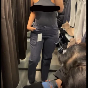 Svarta cargopants - Säljer ett par mörkgrå cargopants i bra skick. De har flera fickor och en dragkedja framtill. Perfekta för en casual look eller när du vill ha något bekvämt men ändå stiligt. Passar till det mesta och är endast använda en gång.