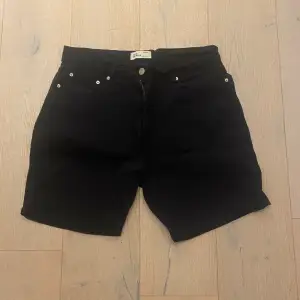 Säljer ett par stilrena svarta shorts från Zara Man i storlek L. De har en klassisk design med knappar och dragkedja framtill. Perfekta för både vardag och sommarens äventyr. Tillverkade i Marocko.