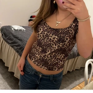 Leopardmönstrad topp - Snygg leopardmönstrad topp i ett stretchigt material. Den är ärmlös och har en tight passform som framhäver figuren. Perfekt för en utekväll eller fest! 🐆