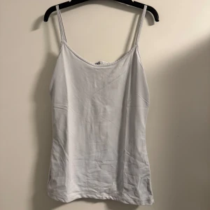 Vita och blåa linnetoppar från Zara - Säljer två snygga linnetoppar från Zara i storlek S. Den ena är vit och den andra är blå, båda med smala axelband. Perfekta för sommaren eller som basplagg året runt. De är i bra skick och gjorda av ett mjukt och bekvämt material.