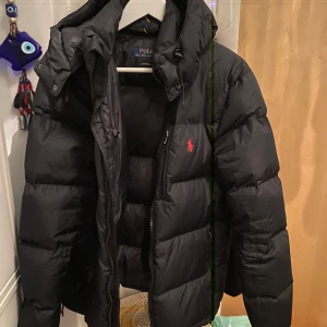  Polo Ralph Lauren jacka svart -  svart dunjacka från Polo Ralph Lauren i storlek S. Kvitto finns. Möts i Stockholm eller fraktar. Den är i nyskick har inte använt den så mycket då jag har en annan vinterjacka. Skriv för fler frågor eller bilder. Byten kan göras men vill helst få pengar. Jackan är slutsåld i sin storlek