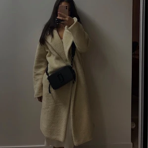 Beige teddyjacka - Säljer en supermysig beige teddyjacka som är perfekt för kyliga dagar. Den har en lång och avslappnad passform med långa ärmar. Jackan är både stilren och bekväm, perfekt för höst och vinter. Passar lika bra till vardags som till festliga tillfällen. 🧥✨