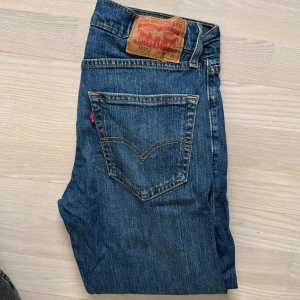 Levi's 502 Jeans 29/32 - Säljer ett par klassiska Levi's 502 jeans i blå denim. De har en normal passform och är i bra skick. Perfekta för vardagsbruk med en tidlös stil. Jeansens material är slitstarkt och bekvämt.