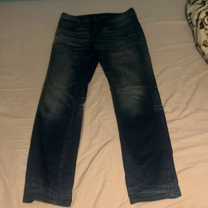 Blå jeans från G-Star RAW - Säljer ett par snygga blå jeans från G-Star RAW, modell 3301 Straight. De har en klassisk rak passform och är i bra skick. Perfekta för både vardag och fest! Har tyvärr inte kvittot. Dom är använda men bra form. Det här är en gammal model så svår att hitta. Pris kan diskuteras.