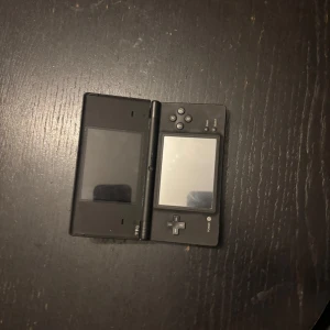 Svart Nintendo DS  - Säljer en svart Nintendo DS i bra skick. Den har dubbla skärmar och klassiska knappar för en nostalgisk spelupplevelse. Perfekt för dig som älskar retrospel eller vill återuppleva gamla favoriter. Laddare och penna ingår ej, men den är lätt att hitta online. Passa på att köpa denna klassiker! 🎮