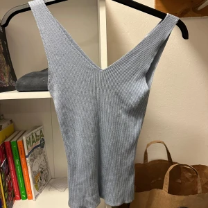 Ljusblå ribbad linnetopp - Säljer en superfin ljusblå ribbad linnetopp. Den är ärmlös och har en djup v-ringning, perfekt för sommardagar eller som ett lager under en jacka. Toppen är i mycket bra skick och passar till både vardag och fest. Skicka ett meddelande vid intresse!