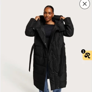 Svart lång dunjacka - Säljer en supermysig svart lång dunjacka med bälte i midjan, köpt från Nelly men är i märket vero moda. Perfekt för kalla vinterdagar! Jackan har långa ärmar och en hög krage som skyddar mot vinden. Den är i mycket bra skick och passar perfekt för både vardag och fest. Håll dig varm och stilren i vinter! 🖤säljer denna för jag har för många jackor, den har en liten hål inne i ena fickan men det går att sy ihop! Köpte för 1650kr inkl. Frakt men säljer den för 1000! Pris kan diskuteras 🤍