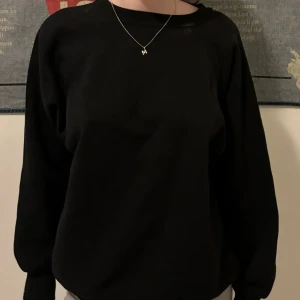 Svart tröja - Säljer en enkel och stilren svart tröja. Perfekt för vardagsbruk med en bekväm passform och långa ärmar. Passar till alla tillfällen och är lätt att matcha med andra plagg.