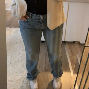 jeans från Gina Tricot - Dessa jeans är perfekta för dig som gillar den trendiga “baggy” looken. Jag köpte dem i en större storlek (44) för att få just den stilen, då jag normalt har storlek 38. Trots den större storleken sitter de riktigt bra, eftersom jag har satt in en extra knapp i midjan som gör att passformen går att justera.  Funktioner: 	•Justerbar midja: Den extra knappen gör det enkelt att anpassa midjan efter hur tight eller lös du vill ha byxorna.   •Byxorna är sparsamt använda, endast 2 gånger.