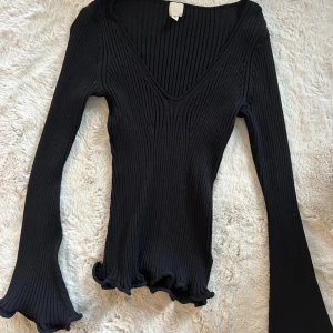 Långärmad topp - Svart topp från H&M med uthängda volang ärmar🖤Är i storlek S men skulle säga att den sitter som en större M