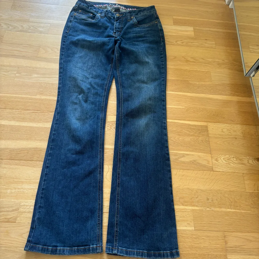 Lågmidjade utsvängda bootcut jeans med fina broderi detaljer på bakfickorna, från John Baner. Midjemått: 76 cm Innerbenslängd: 85 cm Hela längden: 105 cm. Jeans & Byxor.